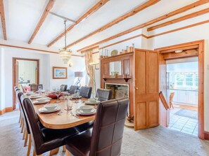 A dining room with a wooden table set for six, a chandelier, and a fireplace. - 5 Bed in Wareham (oc-dc032) (West Lulworth)