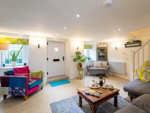 Ein Wohnzimmer mit einer Couch, einem Couchtisch und einer Tür.