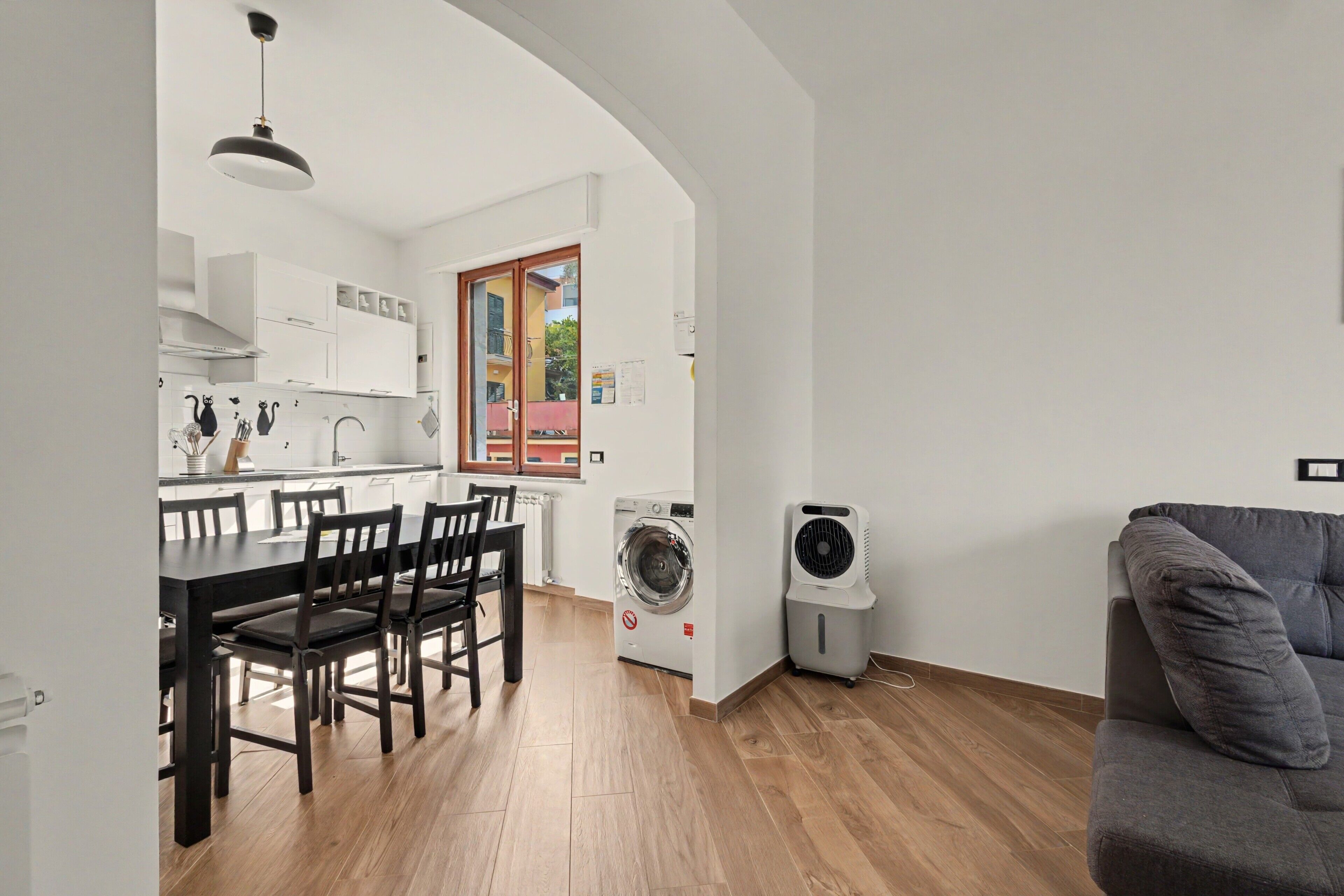 A compact living space with a dining area, kitchen, and a washing machine.