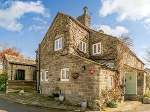 A stone house with a steeply pitched roof, a chimney, and a green door. - 2 Bed in Otley (oc-75268) (Lindley)