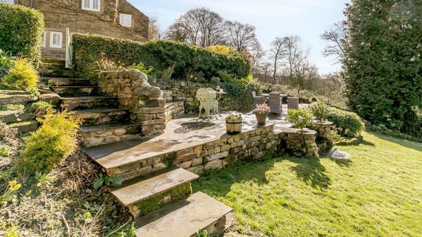 Eine Steintreppe führt zu einem Haus mit Garten.