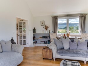 Ein gemütliches Wohnzimmer mit einer Couch, einem Holztisch und einem Bücherregal.