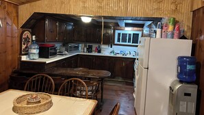A kitchen with wooden cabinets, a microwave, a toaster, and a refrigerator.
