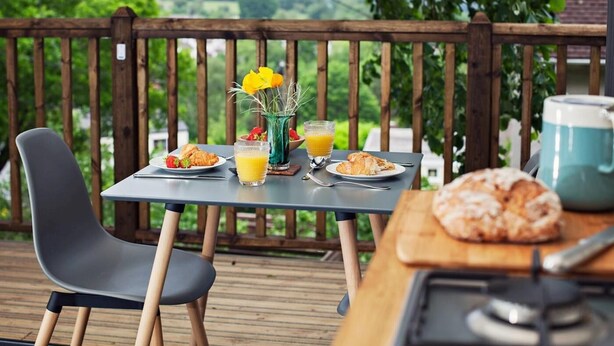 A table with breakfast items, a chair, and a view of greenery. - 1 Bed in Abergavenny (oc-75206) (Gilwern)