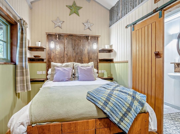 Une chambre à coucher avec un lit en bois, deux tables de chevet, une tête de lit et une décoration en forme d’étoile sur le mur.