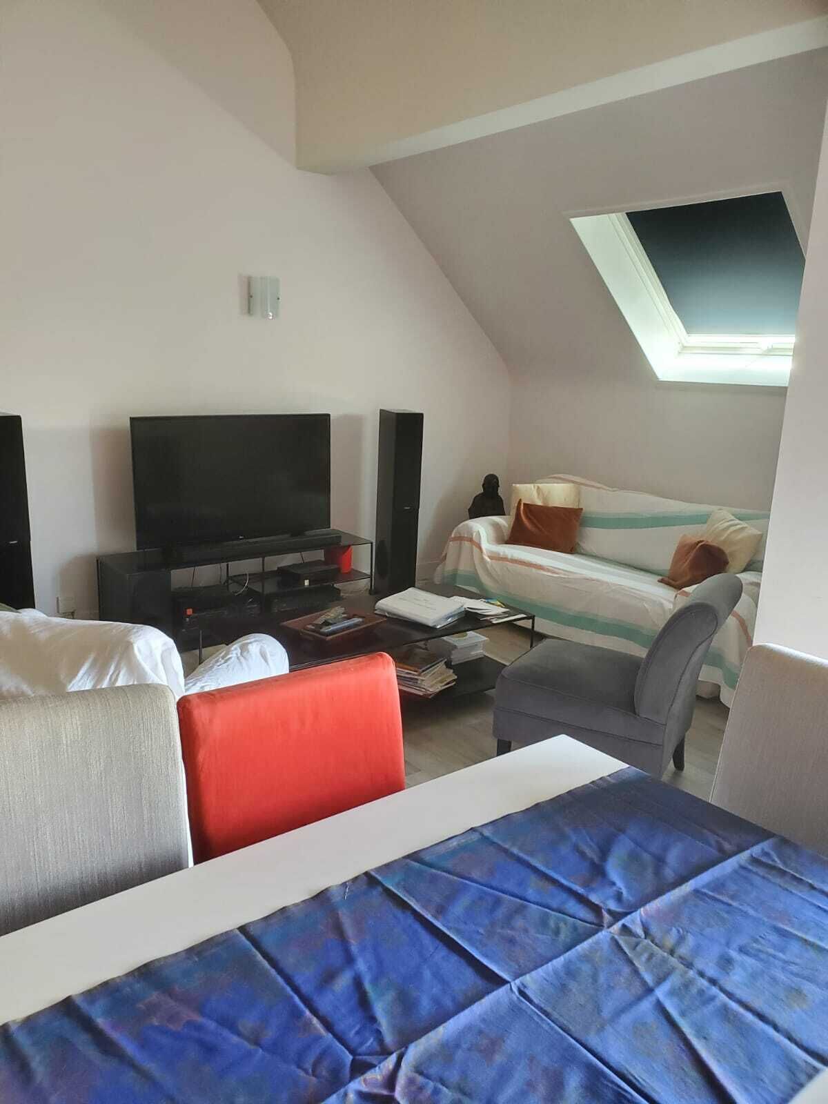 A bedroom with a bed, a TV, a sofa, and a desk.