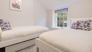 Un dormitorio con dos camas, una ventana con vistas y un cuadro en la pared.