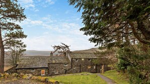 A stone building with a gravel driveway and a pathway leading to the entrance. - 3 Bed in Penrith (oc-sz247) (Dockray)