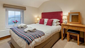 A bedroom with a bed, bedside table, lamp, and a view of the outdoors. - 3 Bed in Penrith (oc-sz247) (Dockray)
