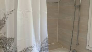 Ein Badezimmer mit Dusche, Badewanne und einem Vorhang mit Blumenmuster.