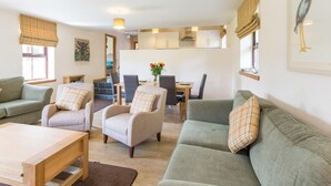 A living room with a sofa, armchairs, a coffee table, and a dining area with chairs and a table. - 1 Bed in Lochgilphead (oc-ca304) (Lochgilphead)
