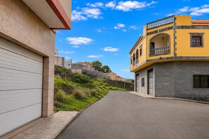 A street with buildings on either side, a clear sky, and a paved road. - GuestReady - La Suerte Family Spacious (Las Palmas de Gran Canaria)