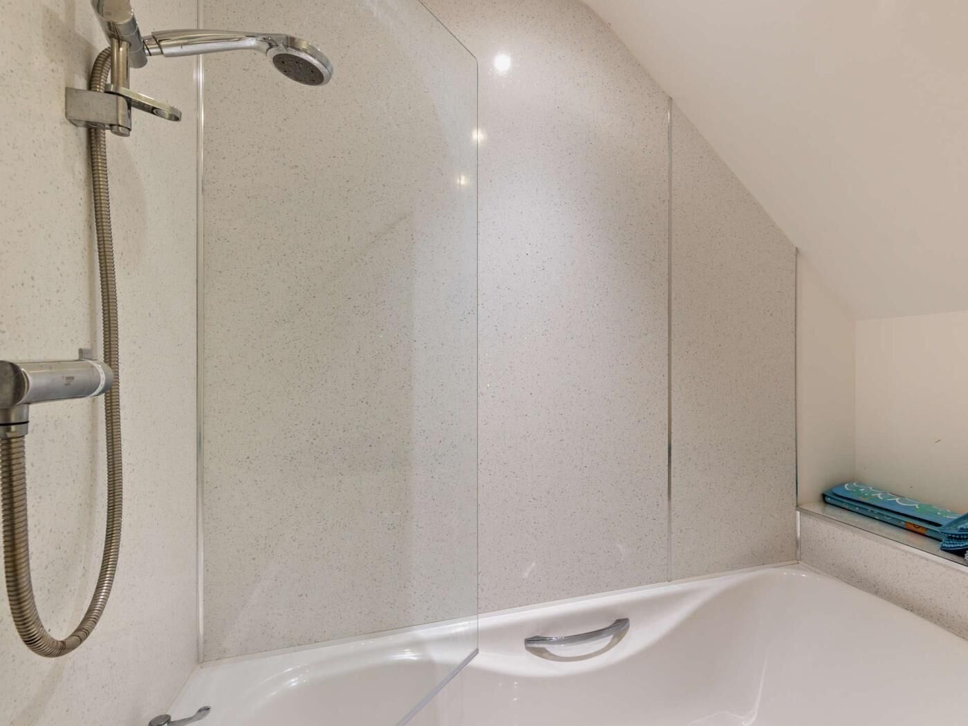 A modern bathroom with a shower, a bathtub, and a towel rack.