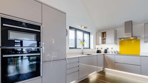 Eine moderne Küche mit integrierten Geräten, einem Fenster und einer gelben Akzentwand.