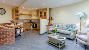 A spacious living area with a dining table, a sofa, and a coffee table. - 2 Bed in Bideford (oc-77292) (Bideford)