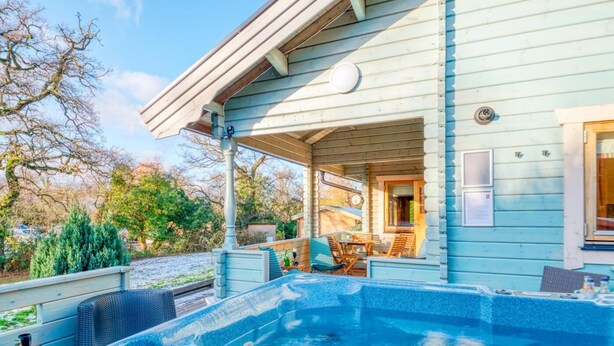Piscina com hidromassagem, área de estar externa e um pátio coberto.