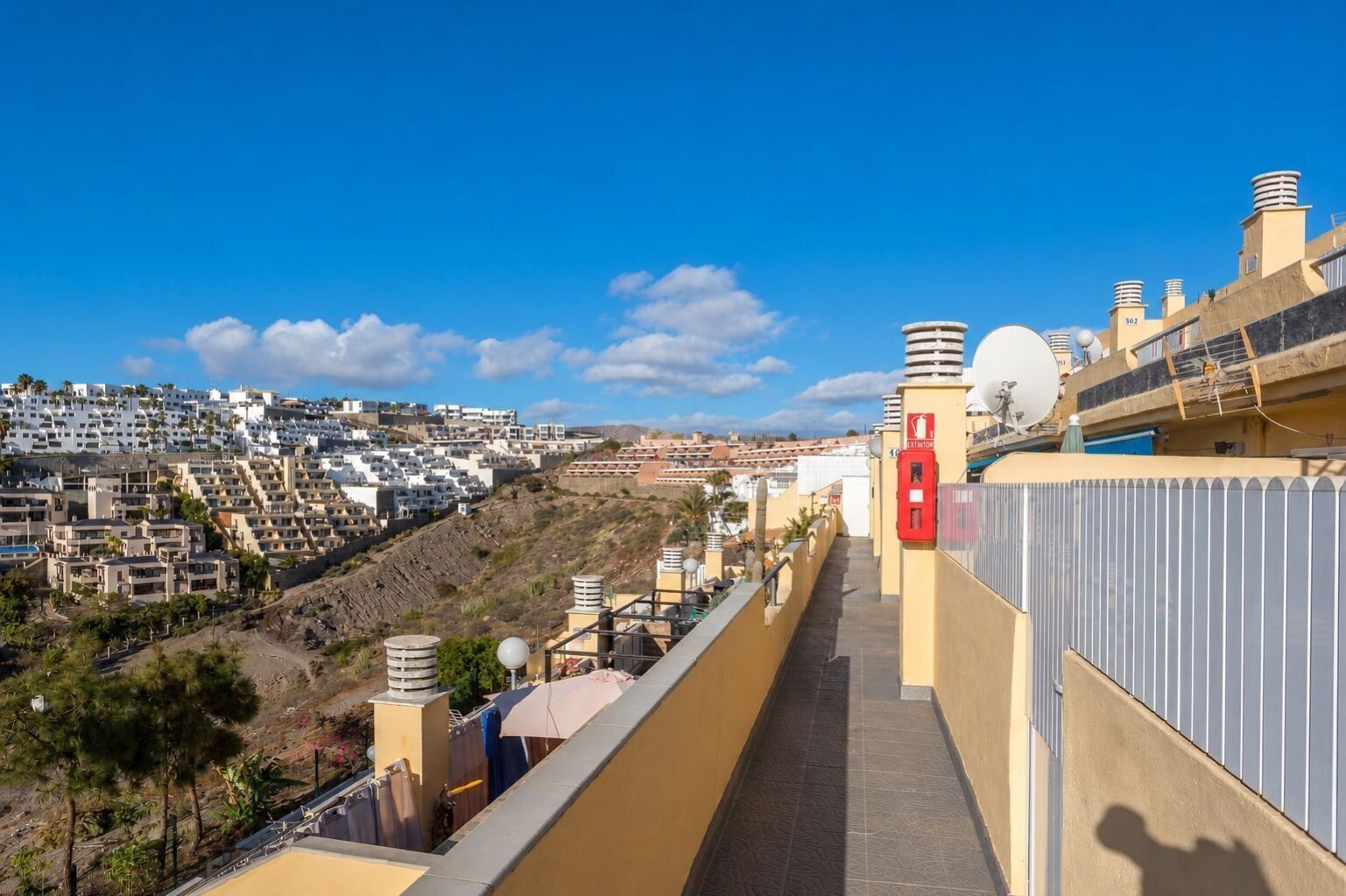 A high vantage point overlooking a densely packed residential area with terraced houses and a clear blue sky.