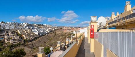 A high vantage point overlooking a densely packed residential area with terraced houses and a clear blue sky.