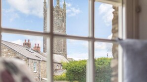 A window view of a stone building with a tower, likely a church or historical structure. - 2 Bed in Bodmin (oc-76604) (Saint Mabyn)