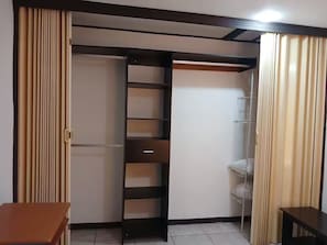 Ein Zimmer mit Schiebetür, einer eingebauten Regaleinheit und einem kleinen Tisch.