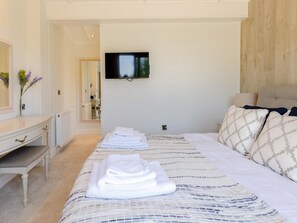 A bedroom with a bed, a TV mounted on the wall, a bedside table, and a mirror. - 2 Bed in Ludlow (oc-78025) (Richards Castle)