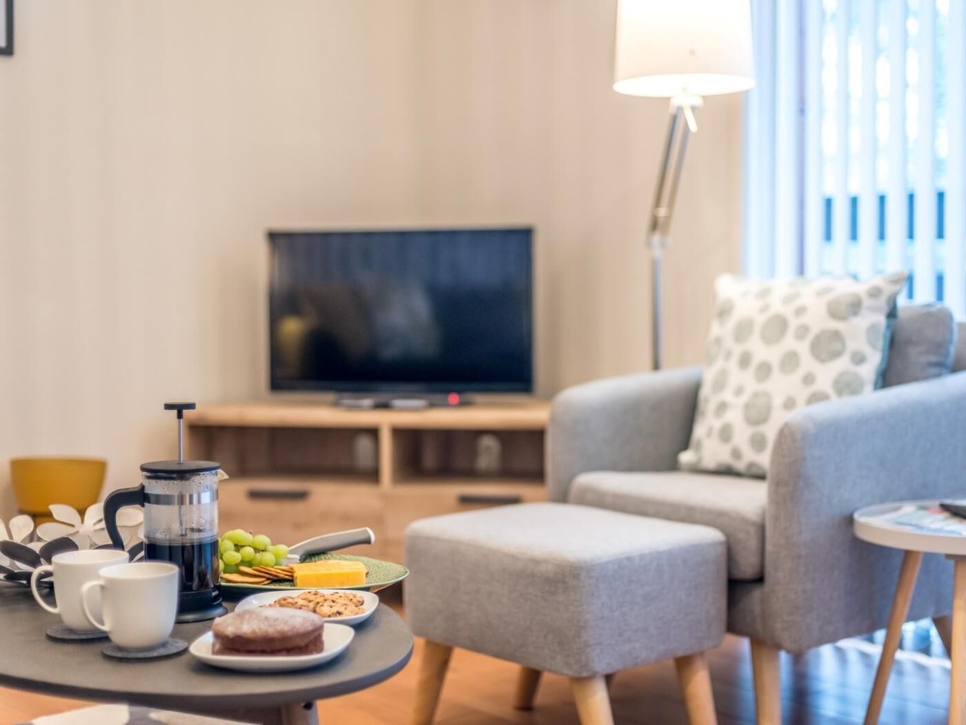 A living room with a sofa, coffee table, and a television.