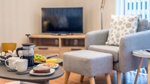 Ein Wohnzimmer mit Sofa, Couchtisch und Fernseher.