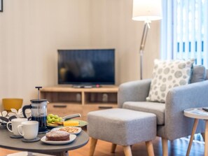 Ein Wohnzimmer mit Sofa, Couchtisch und Fernseher.