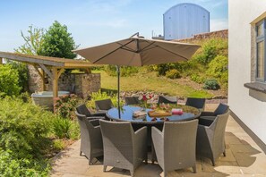 An outdoor patio with a round table and chairs, a pergola, and a large umbrella. - 5 Bed in Wellington (oc-77900) (Ashbrittle)