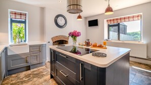 A modern kitchen with a central island, built-in appliances, and a fireplace. - 5 Bed in Wellington (oc-77900) (Ashbrittle)