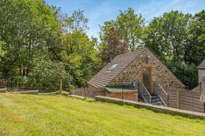 A stone building with a sloped roof, a wooden staircase, and a fenced area. - 1 Bed in Matlock (oc-78225) (Paddocks)