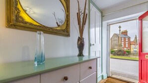 Ein Zimmer mit Spiegel, Vase und Schrank.