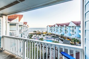 Un hôtel situé en bord de mer, doté de nombreux balcons, d’une piscine et offrant une vue sur l’océan.
