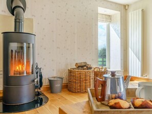 Ein gemütliches Zimmer mit Kaminofen, Korbwannen und einem Wasserkocher auf dem Boden.