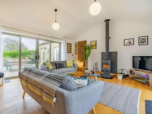 A modern living room with a sofa, a television, a fireplace, and a large window. - 3 Bed in Nr Masham (oc-g0149) (Healey)