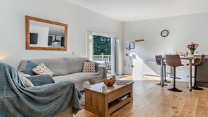 Ein modernes Wohnzimmer mit einer Couch, einem Couchtisch und einem Essbereich mit Stühlen.