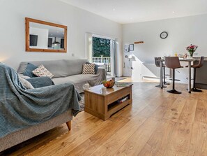 A modern living room with a sofa, coffee table, and dining area with chairs. - 2 Bed in Camborne (oc-82635) (Camborne)