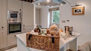 Una cocina moderna con electrodomésticos integrados, una isla central y vistas al exterior.