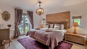 Un dormitorio con cama, mesitas de noche, un candelabro, un espejo y vistas al exterior.