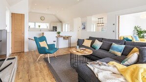 Ein modernes Wohnzimmer mit einer Couch, einem Couchtisch und einem blauen Sessel.