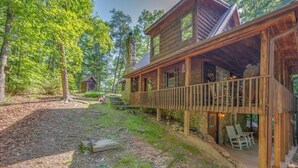 Une cabane en bois dotée d’un porche couvert et de meubles pour s’asseoir à l’extérieur.