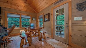 A wooden cabin interior with a dining area, a refrigerator, and a door leading outside. - Private LogHome/ HotTub/Lake Lure/pet (Lake Lure)
