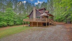A cabin with a wooden deck, a stone chimney, and a covered porch. - Private LogHome/ HotTub/Lake Lure/pet (Lake Lure)