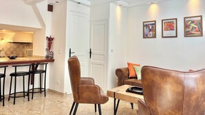 A modern living room with a dining area, a sofa, and a coffee table. - Family home close to the beach and town centre (Trouville-sur-Mer)