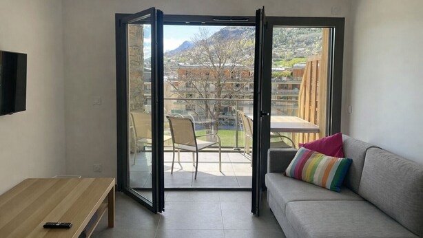 Een moderne woonkamer met een glazen schuifdeur naar een terras.
