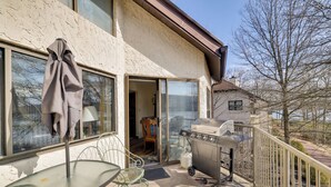 Ein Balkon mit Grill, Tisch und Stuhl.