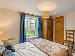 A bedroom with a bed, a window with curtains, a wooden wardrobe, and a chair. - 2 Bed in Lamplugh (oc-sz418) (Lamplugh)