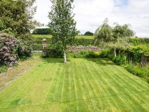 A well-maintained lawn with a stone wall and a variety of plants and trees. - 2 Bed in Lamplugh (oc-sz418) (Lamplugh)
