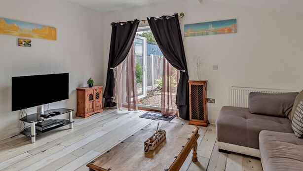 A living room with a TV, wooden coffee table, sofa, and curtains. - 2 Bed in Mablethorpe (oc-74809) (Mablethorpe and Sutton)