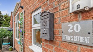 A brick building with a window, a mailbox, and a sign reading '20 HERBY'S RETREAT'. - 2 Bed in Mablethorpe (oc-74809) (Mablethorpe and Sutton)